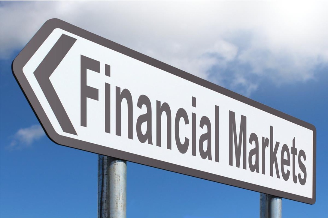 En vägskylt som pekar mot 'Financial Markets' mot en blå himmel.